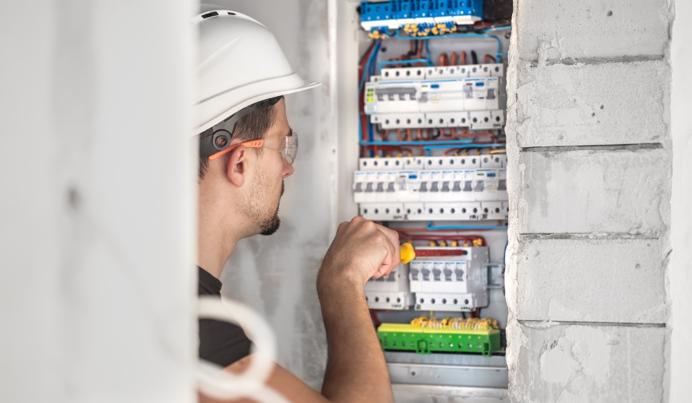 man-electrical-technician-working-switchboard-with-fuses-installation-connection-electrical-equipment